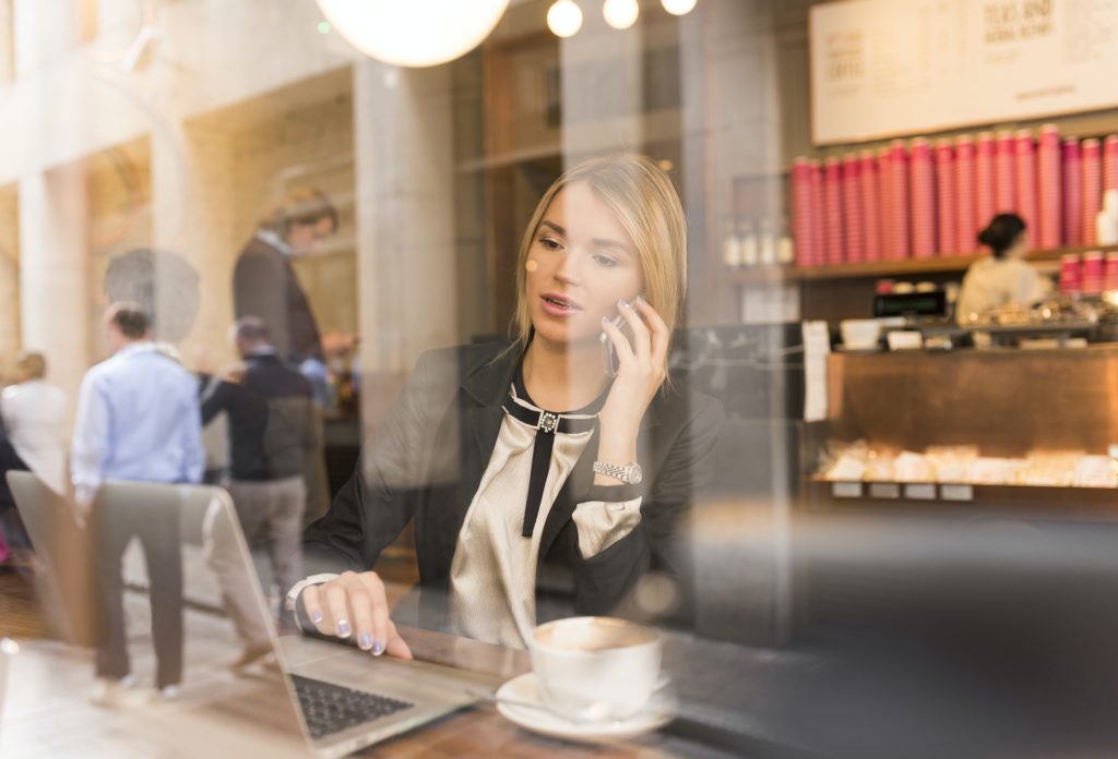 Businesswoman working on laptop in cafe